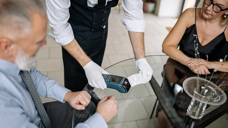 Une personne regardant un écran de téléphone affichant des graphiques financiers, illustrant la gestion budgétaire.