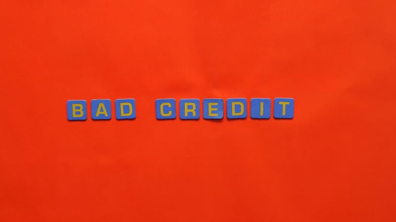 Jeune étudiant analysant des documents financiers et travaillant sur un ordinateur portable